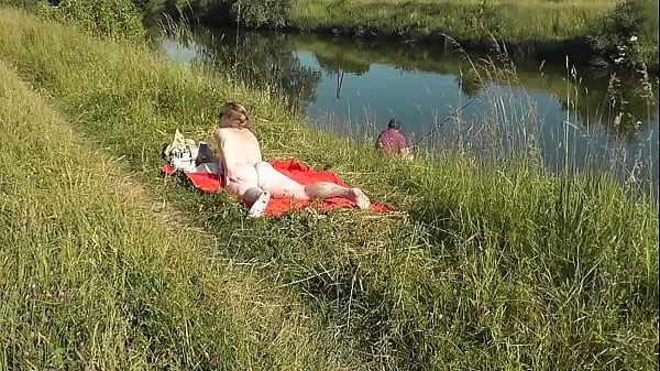 MILF sexy Frina on river bank undressed and sunbathes naked. Random man fisherman watching for her, and in the end decided to join naked woman. Wild beach. Nudist beach. Public nudity. Public exposure. Naked in public